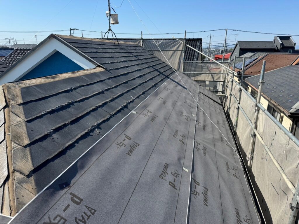 屋根カバー工法で防水性能を高めるための防水シート貼り付け作業