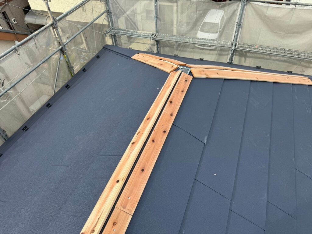 屋根の頂部に新しい棟板金を取り付け、仕上げるカバー工法の工程