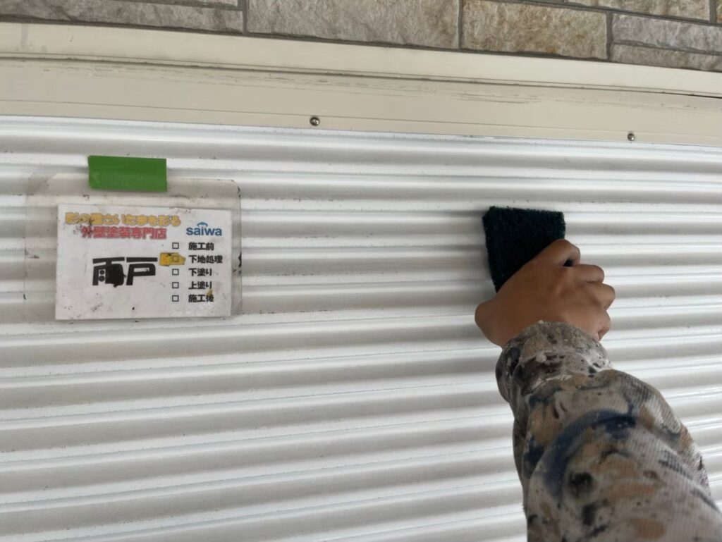 スプレー塗装前に雨戸の表面を整えるケレン作業