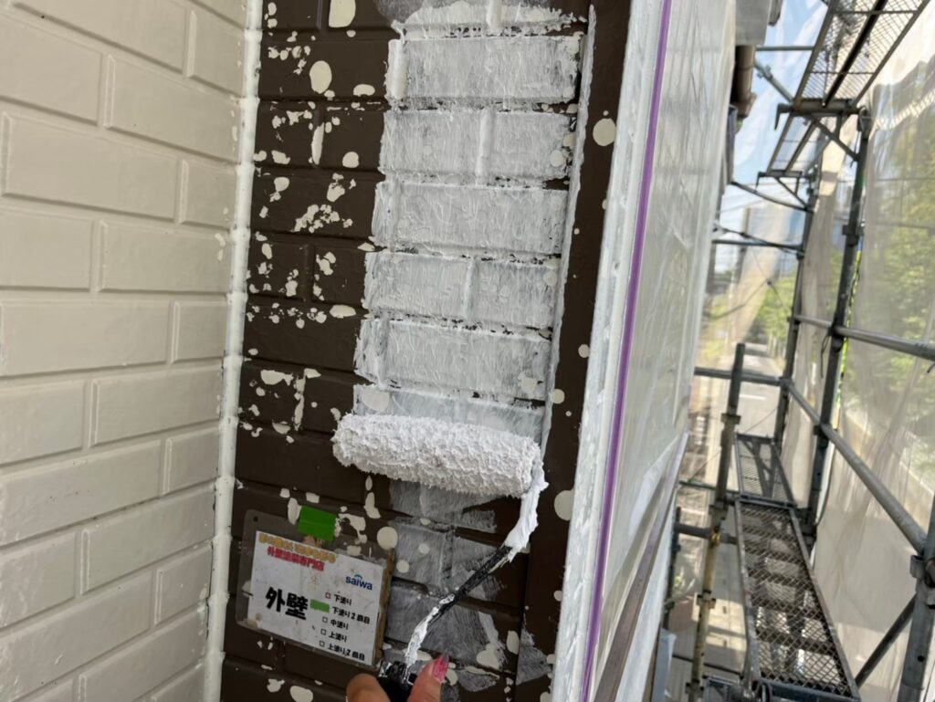 外壁の耐久性を高めるため、2回目の下塗りを行っている工程