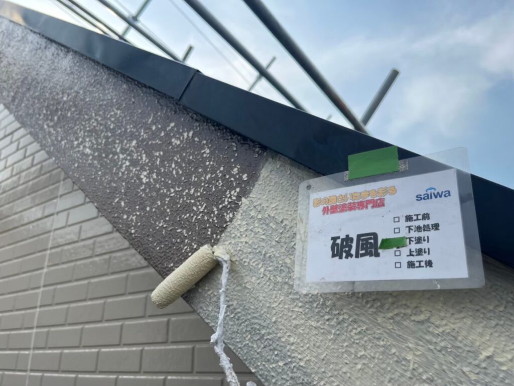 耐久性を高めるため、破風板に2回目の下塗りを行う様子