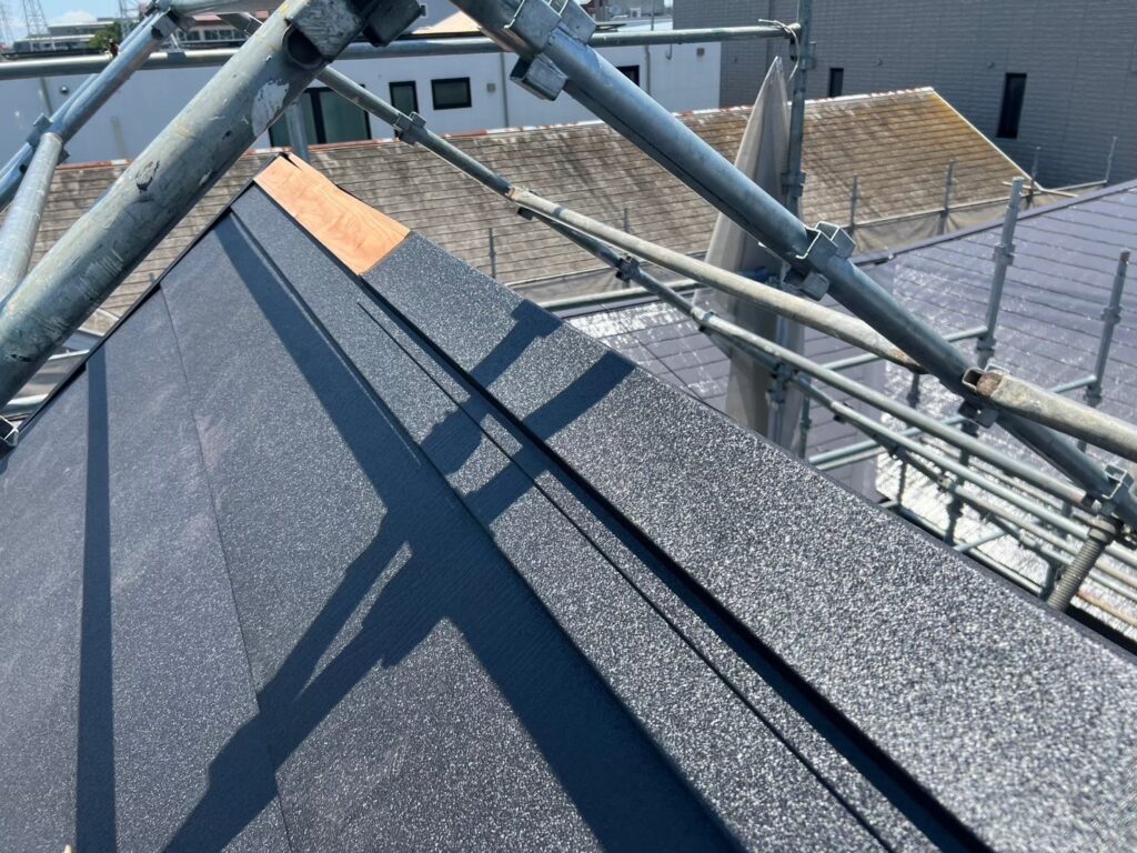 スーパーガルテクトの屋根に棟板金を取り付けている最終工程の様子