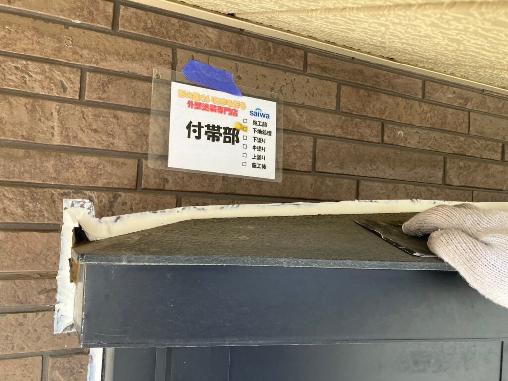 資格保有職人 出窓の旧塗膜を丁寧にケレン掛けしている写真。