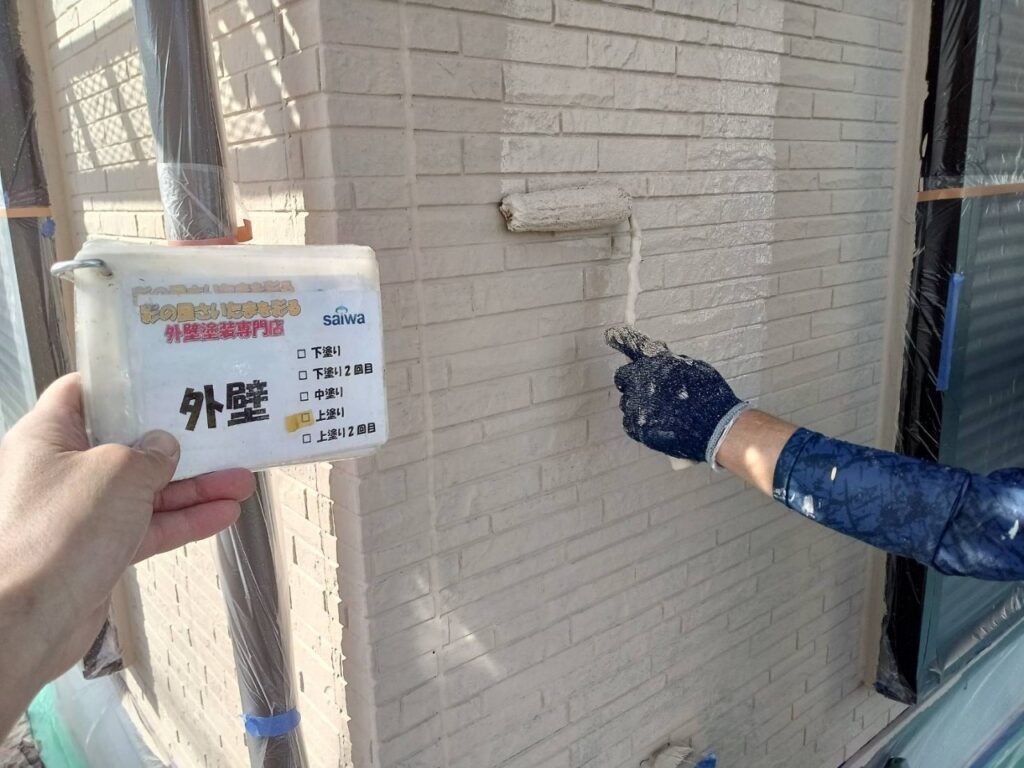 GAINA 19-70Dで上塗りを施工している写真。高品質な仕上がりと防水性能を向上させる工程