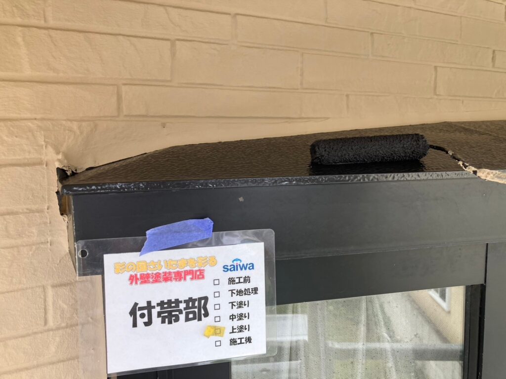 出窓の仕上げ塗装で上塗りを丁寧に施工している様子