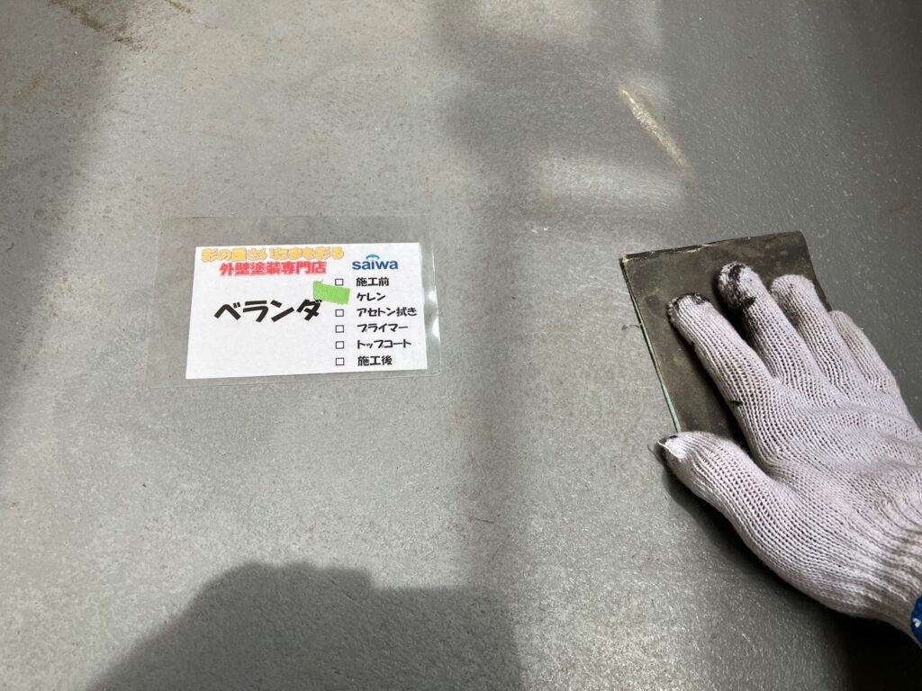 資格保有職人がベランダ床の密着性向上のためにケレン掛けを行っている様子