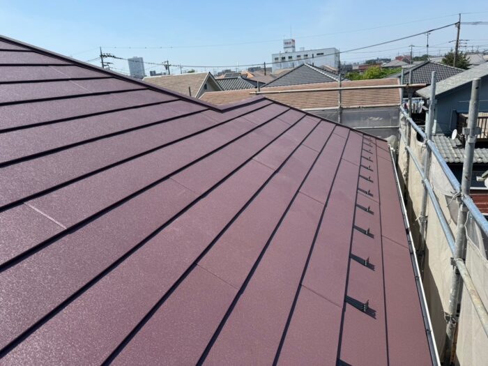 スーパーガルテクト（シェイドワインレッド）で仕上げた屋根の施工後写真。耐久性が向上し、美観も高い状態